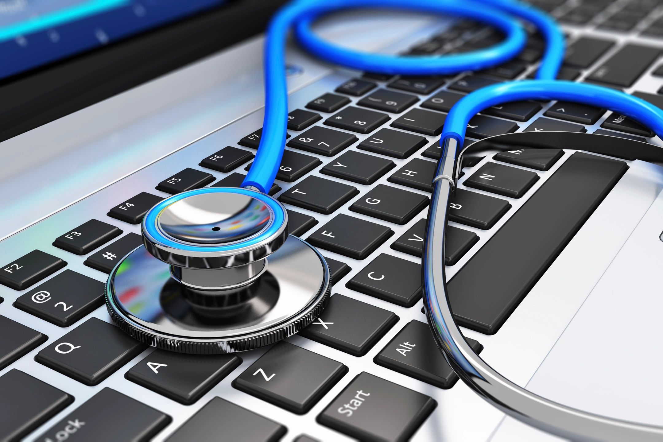 A stethoscope rests on a computer keyboard.