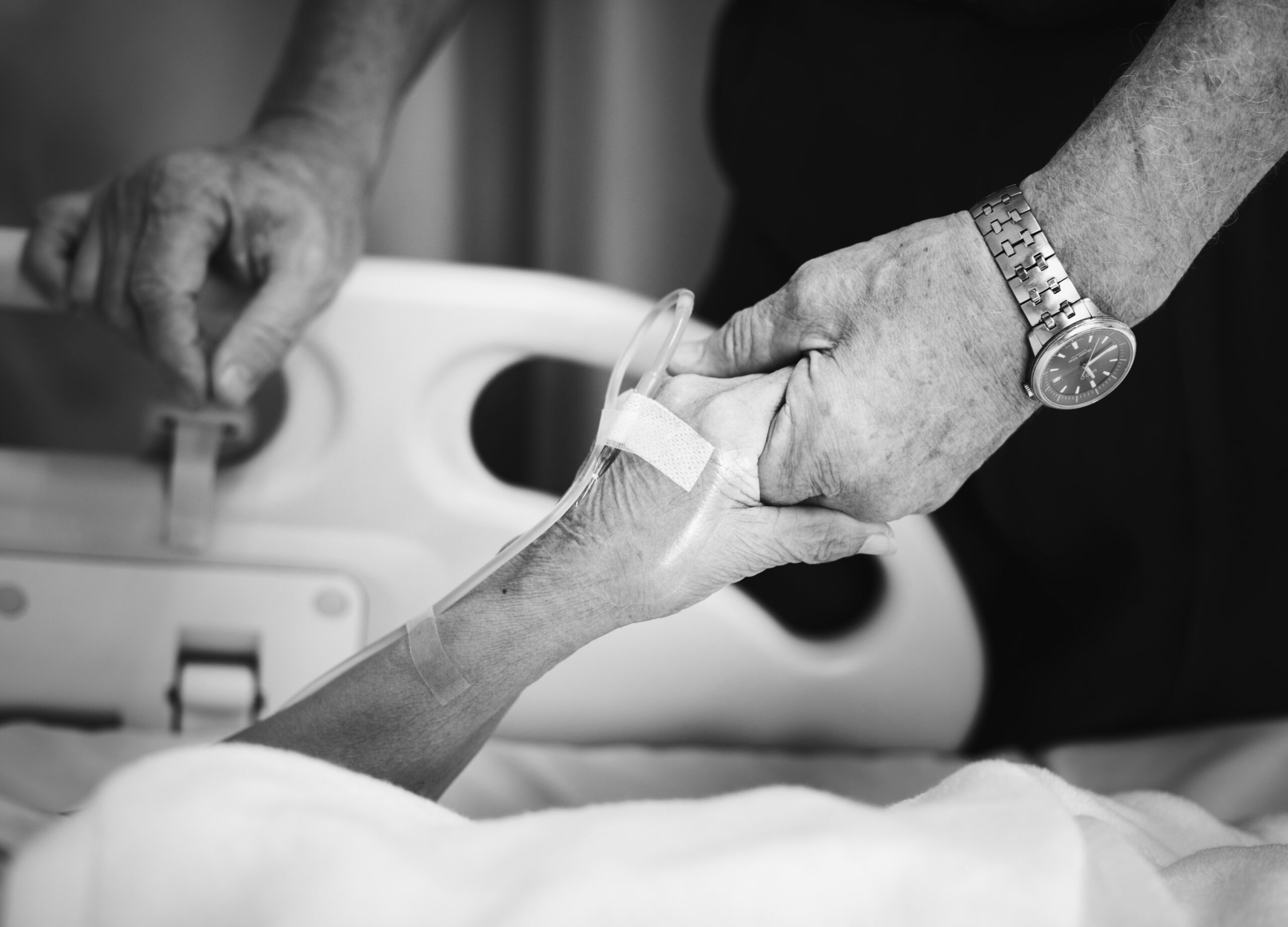 Holding hands from hospital bed.