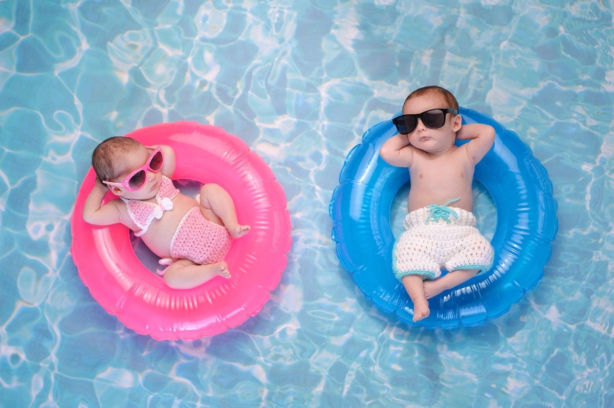 two babies in a pool on floaties