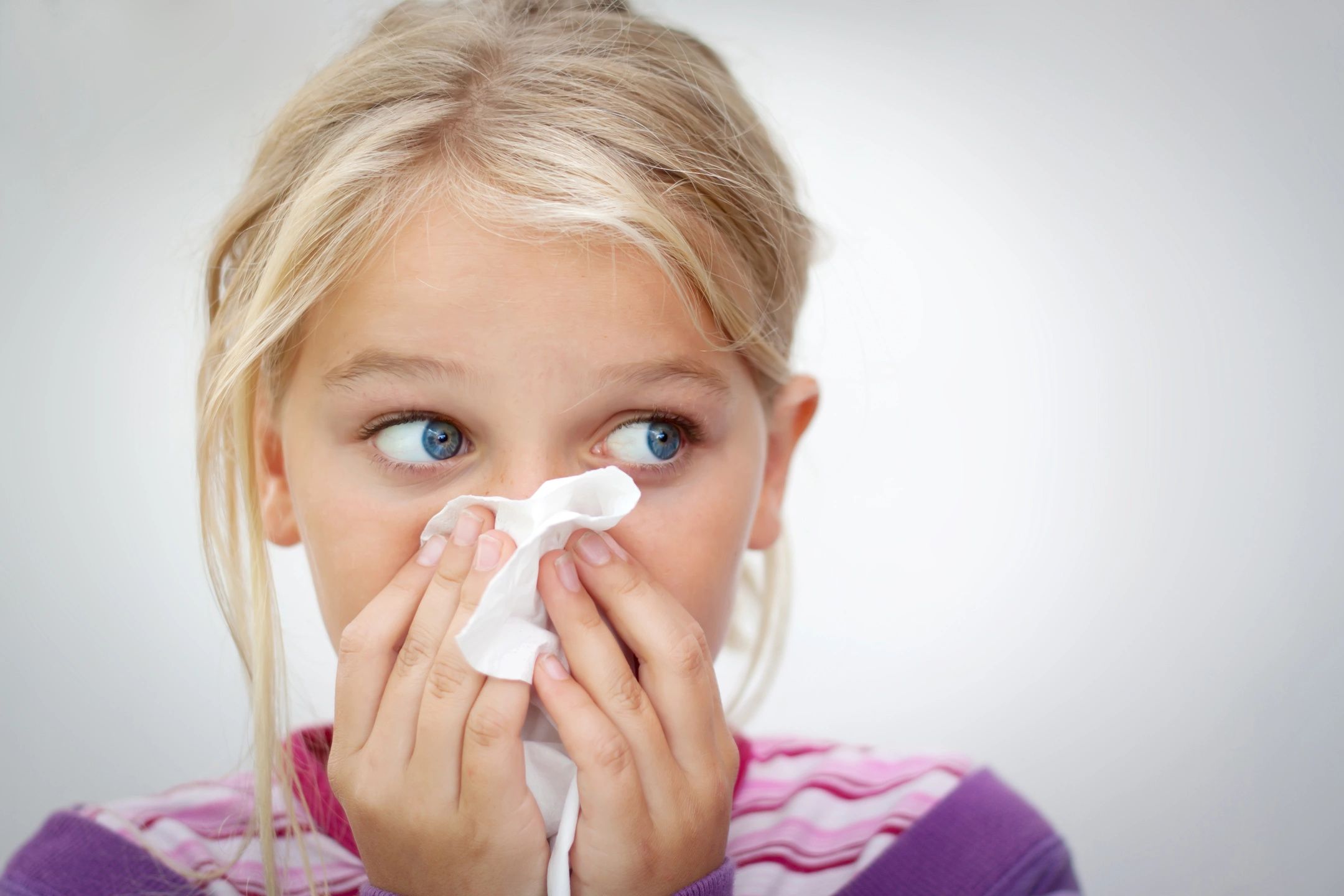 blonde child using kleenex