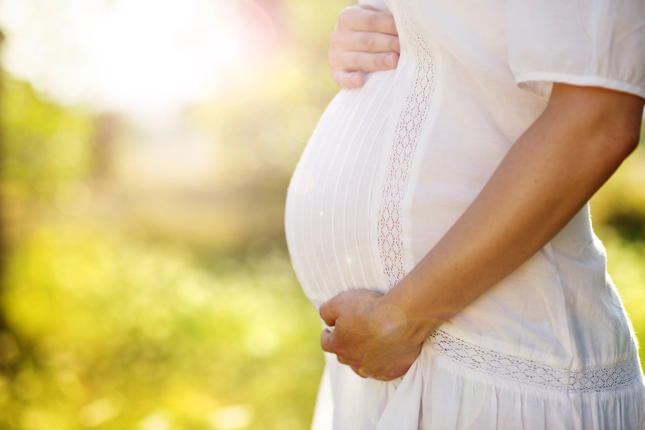 Hands cradling a pregnant belly